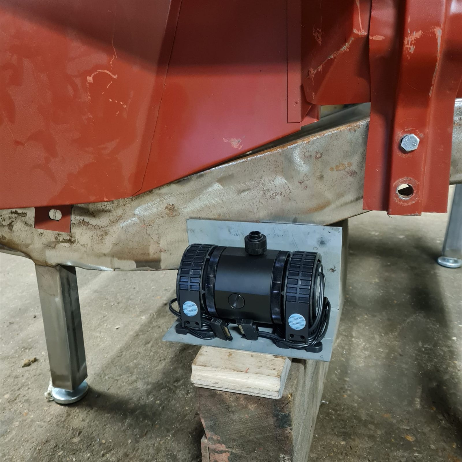 Water-cooling pump mounted on a fabricated bracket beneath the Willys Jeep bonnet structure